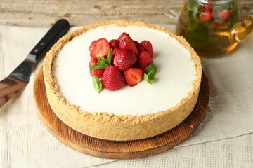 Tasty cheesecake with strawberries and mint on wooden table, closeup