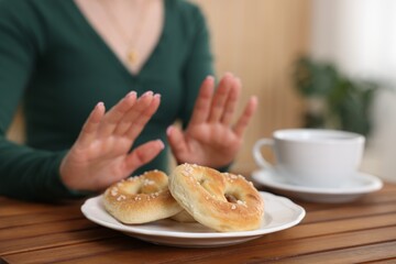 Gluten free diet. Woman refusing from pretzels indoors, selective focus