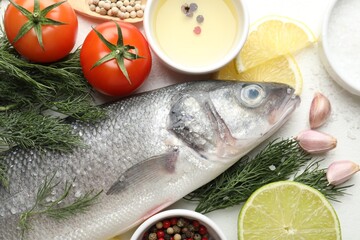Fresh raw seabass with spices on white table, flat lay. Fish and seafood delicacies