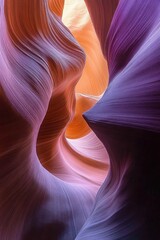 Obraz premium Narrow, winding sandstone canyon with smooth, flowing walls illuminated by warm light creating an abstract, colorful natural sculpture