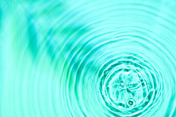 Texture of water drops and shadow of tree branch on turquoise background, closeup