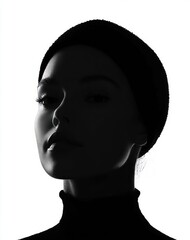High contrast black and white profile portrait of a woman wearing a beanie and turtleneck, casting dramatic shadows with a calm and mysterious expression