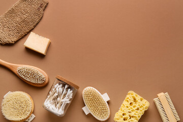 Composition with massage body brushes, bath sponges and jar with cotton swabs on brown background