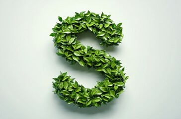 Green leaves arranged creatively in the shape of the letter S on a plain light background, symbolizing nature and growth