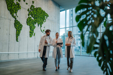 Doctors walking and discussing diagnosis in hospital lobby with world map
