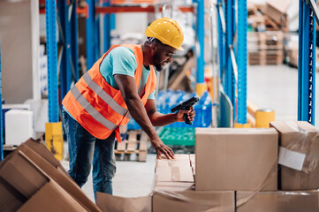 Warehouse worker scanning packages with barcode scanner in distribution center