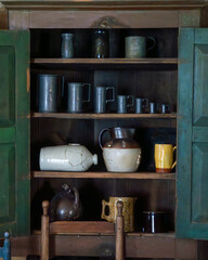 A cabinet with antique jugs and jars