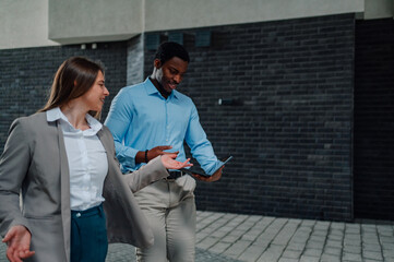 Business colleagues discussing work using tablet outdoors