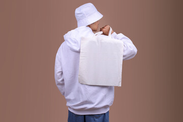 Back Shot of a Male Model Holding a Blank Canvas Tote Bag for Mockup Concepts