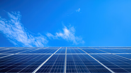 Wide view of modern solar panels with blue sky and clouds, representing clean renewable energy and sustainable technology