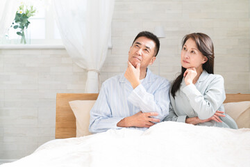 起きてベッドの上で会話をする夫婦