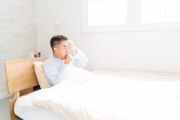 ベッドの上で咳き込む男性