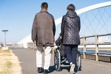 車椅子を押して散策をする親子