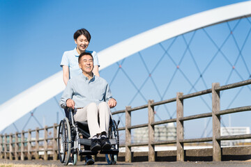 車椅子を押して散策する男性と介護士