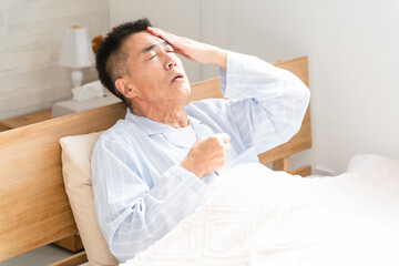 ベッドの上で咳き込む男性
