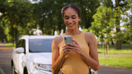 African American woman new electric car automobile auto vehicle smile girl using mobile phone...
