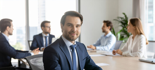 A portrait of a leader smiling confidently at the conference table.