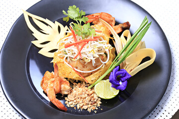 Shrimp Pad Thai, traditional Thai dish with stir fried rice noodles, shot from above on a rustic texture