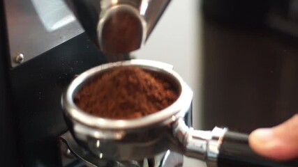 Barista fill the portafilter with coffee grounds to make espresso	