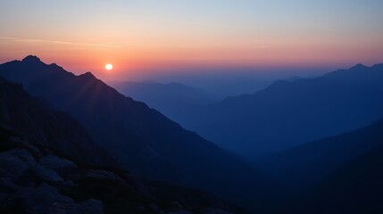 Fototapeta premium Sunrise paints the mountain range with hues of orange, pink, and deep blue, creating a serene and breathtaking landscape