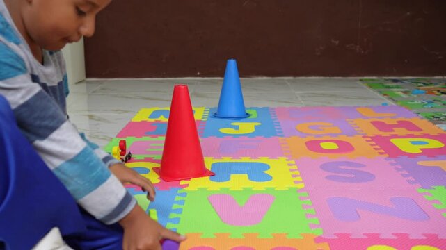 hispanic kindergarten boy playing with colorful number train on a foam alphabet mat. early math skills, and playful education, Children engaged in hands-on learning activities at a preschool classroom