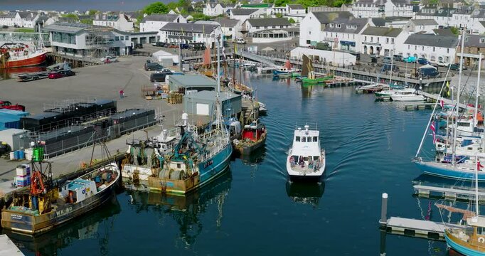 Local tourist wildlife excursion boat Shearwater is seen moving out of Ullapool marina, heading towards the Summer Isles along the scenic NC500 coastal route.