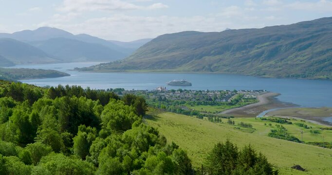 Breathtaking low-to-high reveal shot capturing Ullapool village from above, showcasing its charming streets and stunning coastal backdrop.
