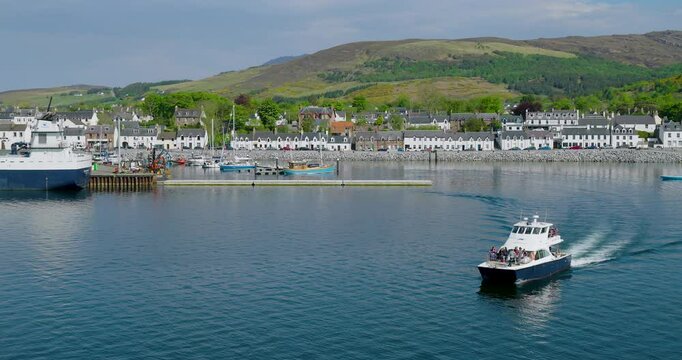 Local tourist wildlife excursion boat Shearwater departs Ullapool, heading out towards the Summer Isles along the scenic NC500 coastal route.