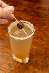 Exotic Tamarind (Tamarindo) Margarita cocktail with a salt and chili rim, garnished with fresh...