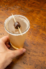 Exotic Tamarind (Tamarindo) Margarita cocktail with a salt and chili rim, garnished with fresh...