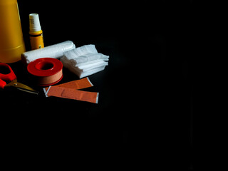 First aid items are arranged on a dark surface. 
