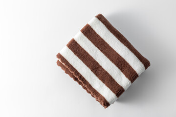 Soft Brown and White Striped Towel Folded Neatly on White Surface