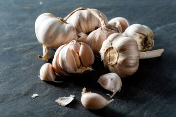 Fresh Garlic Bulbs and Cloves on Dark Slate Background