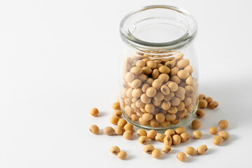 Glass Jar Filled with Yellow Soybeans on a White Background