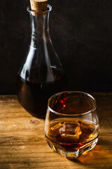 Elegant Whiskey Glass Beside a Bottle on Rustic Wooden Table