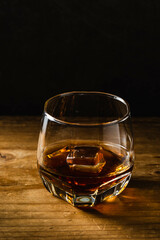 Elegant Glass of Whiskey with Ice on Dark Wooden Table