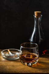 Elegant Glass of Whiskey with Stylish Carafe and Ashtray on Table
