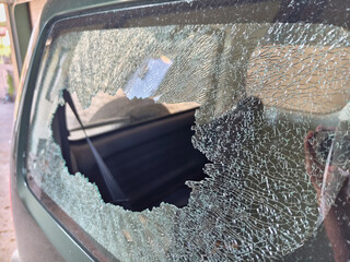 Thief broken car window. Criminal incident and vandalism on the city streets.