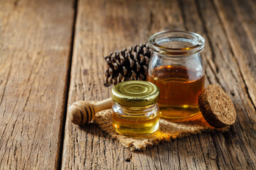 Natural Honey and Glass Jar on Rustic Wood Table with Pinecone