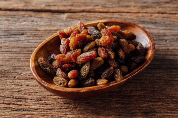 Assorted Dried Raisins in Wooden Bowl on Rustic Wooden Table