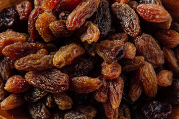 A Close-Up View of Various Types of Dried Raisins on Wood Surface