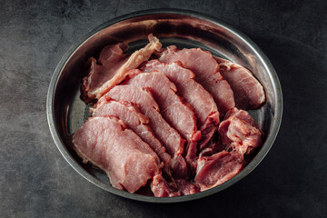 Slices of Fresh Pork Meat on Steel Plate Ready for Cooking