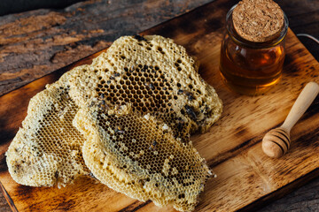 Natural Honeycomb with Honey Jar and Wooden Dipper on Rustic Board