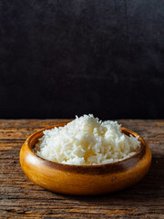Cooked White Rice in Wooden Bowl on Rustic Wooden Surface
