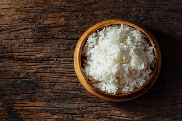 Cooked White Rice in Wooden Bowl on Rustic Wooden Table Surface