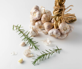 Fresh Garlic Bulbs and Rosemary Sprigs on Clean White Surface