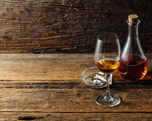 Elegant Glass of Whiskey Beside Decanter on Rustic Wooden Table