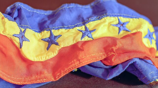 Crinkled Venezuelan flag on dark surface, close-up
