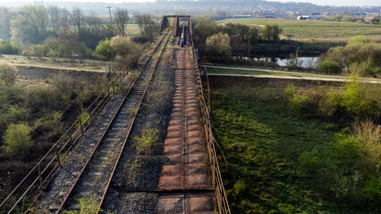 Aerial view of old, derelict railway bridge with overgrown tracks