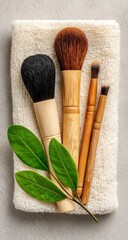 Makeup brushes on a beige towel with green leaves